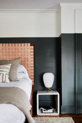 a bedroom with a bed and a table with a lamp at Blind Tiger Portland - Danforth Street Guest House in Portland