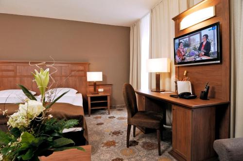 a hotel room with a bed and a desk with a computer at Hotel BurgGartenpalais in Rothenburg ob der Tauber