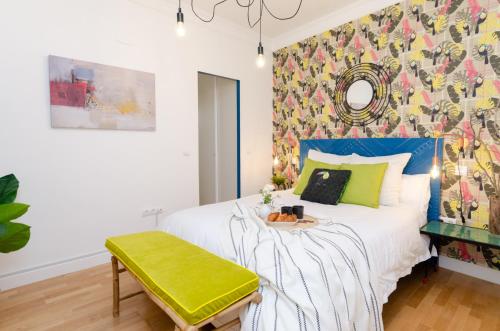 Un dormitorio con una cama con un banco verde al lado en Palacio Premium Stay, en Madrid