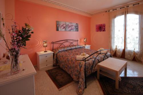 a bedroom with a bed and a vase of flowers at B&B Le Tre rose dell'Etna in Zafferana Etnea