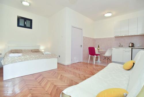 a white room with a bed and a kitchen at Apartment Stari Grad in Budva