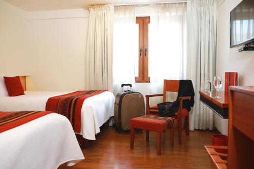 pokój hotelowy z 2 łóżkami i oknem w obiekcie San Agustin Plaza w Cuzco