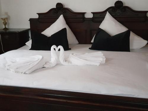 two white swans laying on top of a bed at Appartement Emilia in Hallstatt