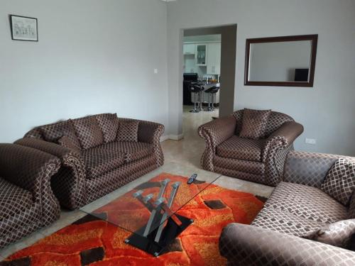 a living room with two chairs and a table at Sheilas home away from home in Lusaka