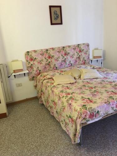 - une chambre dotée d'un lit avec un couvre-lit floral dans l'établissement Appartamento La conchiglia, à Lido di Camaiore