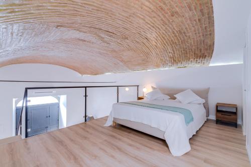 um quarto com uma cama e um tecto em madeira em DREAM OF LOFT em Olhão