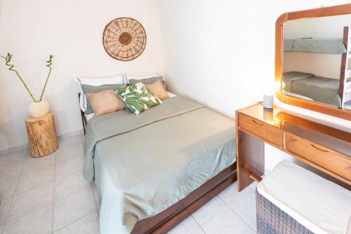 Dormitorio pequeño con cama y espejo en Puerto Seaside Rooms, en Akhladherí