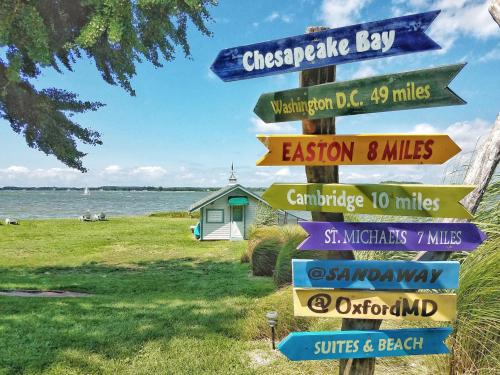a directional sign with many signs on a pole at Sandaway Suites & Beach in Oxford
