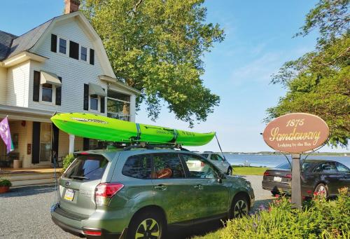 a car with a surfboard on top of it at Sandaway Suites & Beach in Oxford