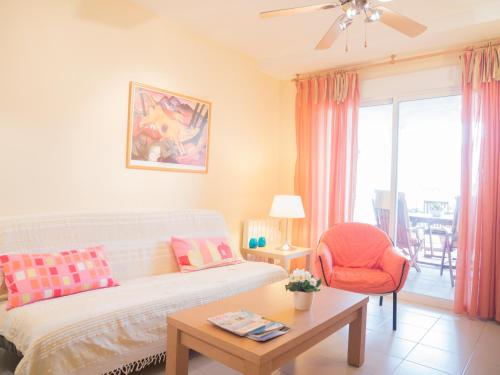 een woonkamer met een bank en een stoel bij Marineu Alcocebre Apartamentos Serena Mar in Alcossebre
