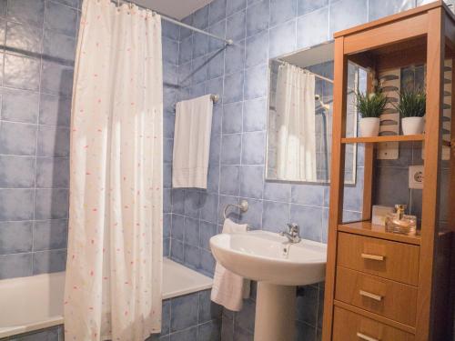 een badkamer met een wastafel en een douchegordijn bij Marineu Alcocebre Apartamentos Serena Mar in Alcossebre