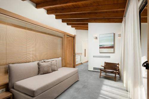 a living room with a couch and a chair at Amaré Chania Luxury Residence in Stérnai