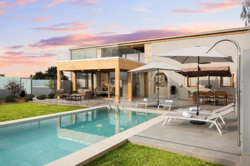 een villa met een zwembad en een huis bij Amaré Chania Luxury Residence in Stérnai