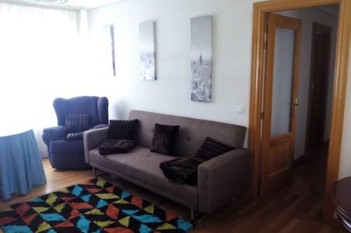 a living room with a couch and a chair at APARTAMENTO CONGRESO in Logroño