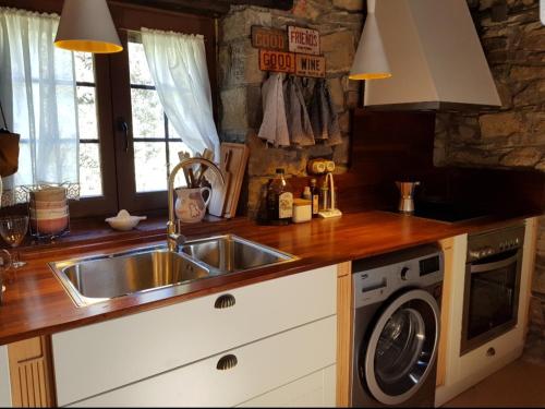 una cocina con fregadero y lavadora en PALLERO BAIXO, en Las Colladas