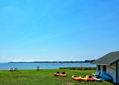 a group of kayaks on the grass next to a house at Sandaway Suites & Beach in Oxford
