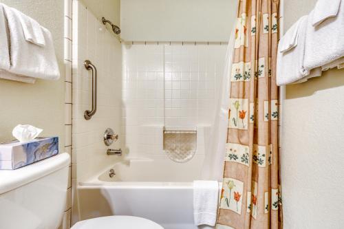 a bathroom with a tub and a toilet and a shower curtain at Osprey Cove in Barview