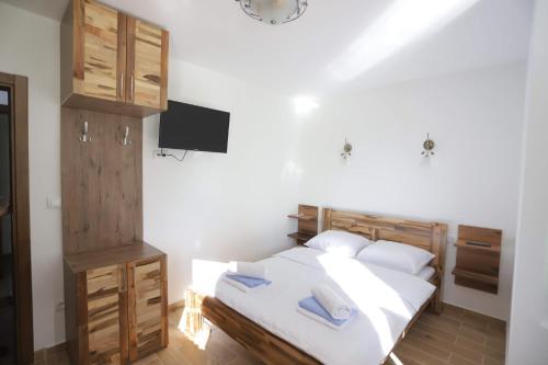 1 dormitorio con 1 cama con sábanas y almohadas blancas en Vila PARADIZO-ZLATAR, studio apartman 1, en Nova Varoš