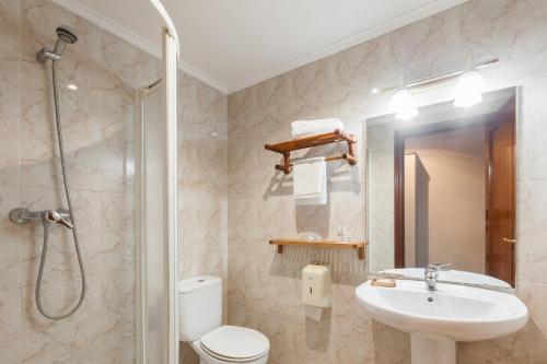a bathroom with a toilet and a sink and a shower at Zumaia Hotela in Zumaia