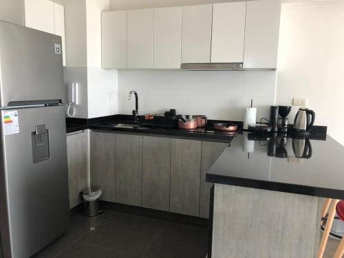 een keuken met witte kasten en een koelkast bij Connect in Lima