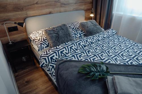 een bed met blauwe en witte lakens en kussens bij Apartament Centrum 2 sypialnie i salon in Szklarska Poręba
