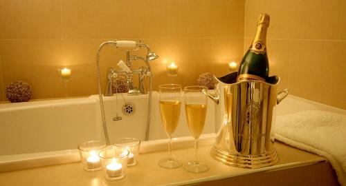 a champagne bottle in a bucket and glasses on a table at Ffarm Country House in Abergele