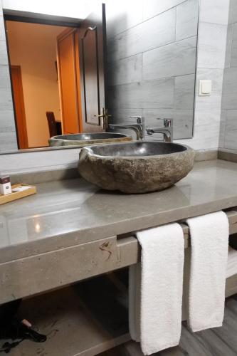 a bathroom with a large stone sink and towels at Casa da Eira in Cadaval