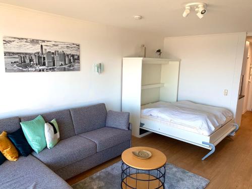 ein Wohnzimmer mit einem Sofa und einem Bett in der Unterkunft Meerblick Riviera 140 in Scharbeutz