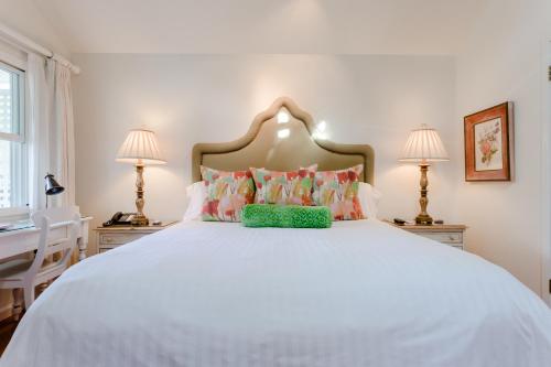 a bedroom with a large white bed with two lamps at Cottage Grove Inn in Calistoga