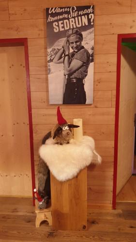 a dog wearing a santa hat sitting on a stump at Hotel Mira in Sedrun
