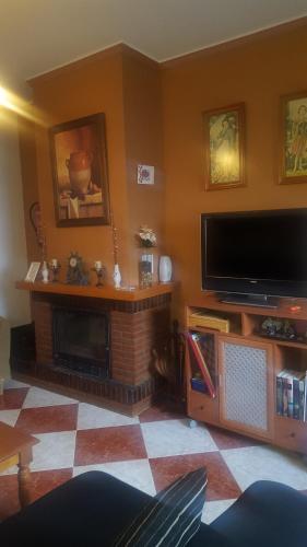 salon z kominkiem i telewizorem z płaskim ekranem w obiekcie El Rengue w mieście Casabermeja