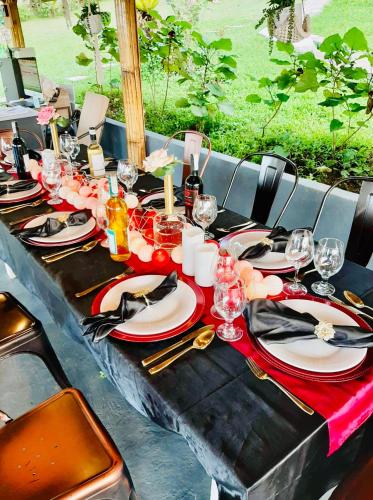 a long table with plates and wine glasses on it at Bintana sa Paraiso Binunsaran in Mambajao