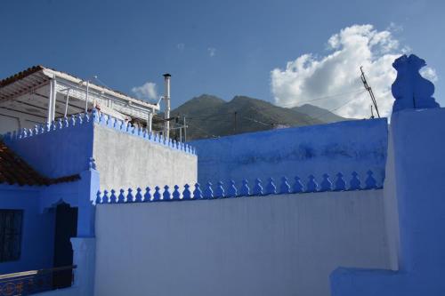 a blue fence on the side of a white building at Casa Perleta in Chefchaouene