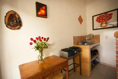 a kitchen with a vase of flowers on a table at Htl & Villas Las Glorias Mazamitla, céntricas, parking, jardín in Mazamitla