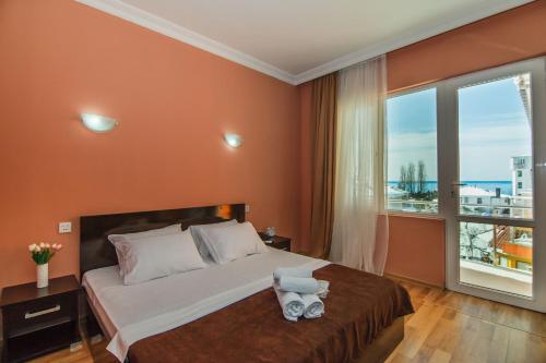 a bedroom with a large bed and a large window at Hotel Egrisi in Gonio