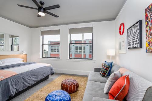 a bedroom with a bed and a couch and windows at Norblad Hotel in Astoria, Oregon