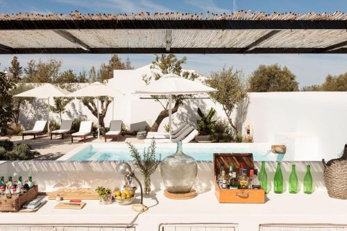 a table with bottles on it next to a pool at Hospedaria in Cabanas de Tavira