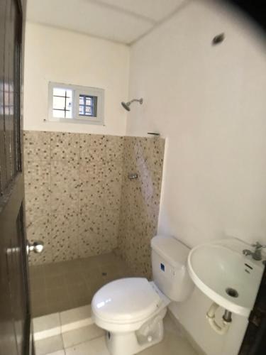 a white bathroom with a toilet and a sink at Apartamentos Doña Amelia in Chitré