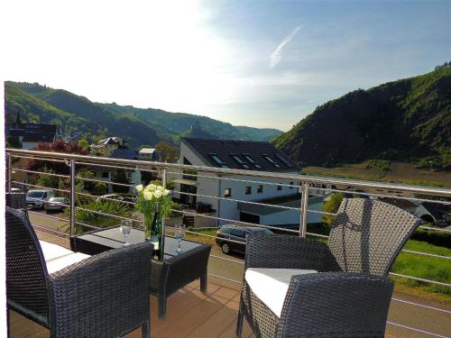 a balcony with chairs and a table with flowers on it at Ferienwohnungen Krause in Cochem