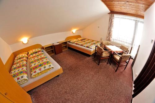 a room with two beds and a table and chairs at Pension 444 - Ski Resort Herlikovice and Bubakov in Vrchlabí