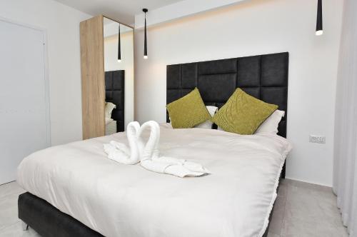 a bedroom with a white bed with two white towels at וילה דולב in Eilat