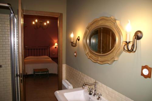 baño con lavabo y espejo en la pared en El Naranjo, en Casas del Monte