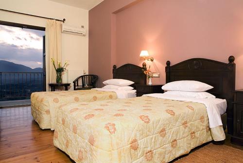 Een bed of bedden in een kamer bij Vytina Mountain View Hotel