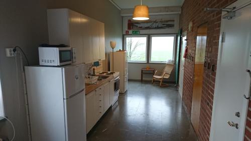 een keuken met een witte koelkast en een magnetron bij Tossene Vandrahem in Hunnebostrand
