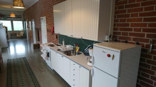 a kitchen with white appliances and a brick wall at Tossene Vandrahem in Hunnebostrand