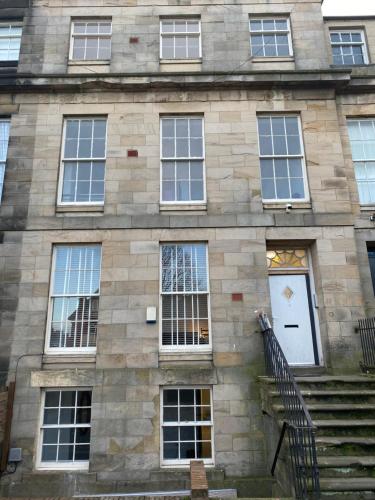 a stone building with a white door and windows at Westgate Apartments in Newcastle upon Tyne