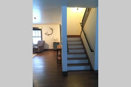 a hallway with a staircase and a living room at Silver Birch Vacation Rental in Talkeetna