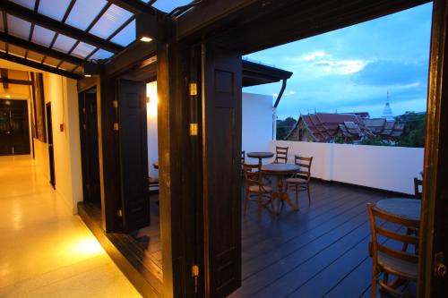 a room with a table, chairs, and a window at 99 The Gallery Hotel- SHA Extra Plus in Chiang Mai