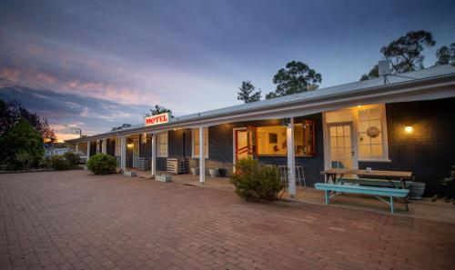 a building with a picnic bench in front of it at The Platypus Accommodation & Cafe in Cudal