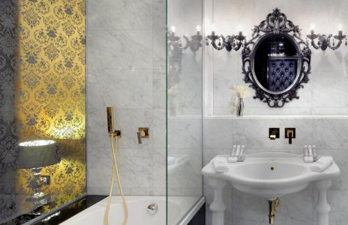 a white bathroom with a sink and a shower at Hotel Nox in Ljubljana